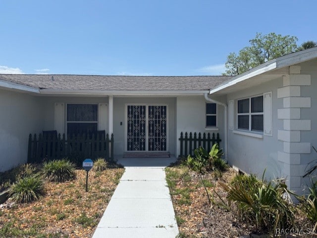 property entrance featuring fence and stucco siding