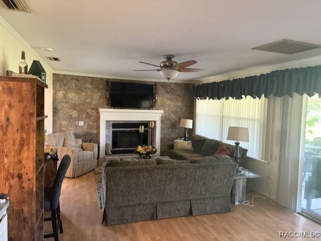 living room featuring crown molding, a ceiling fan, wood finished floors, and visible vents