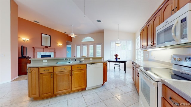 kitchen featuring white appliances, visible vents, a sink, vaulted ceiling, and light countertops