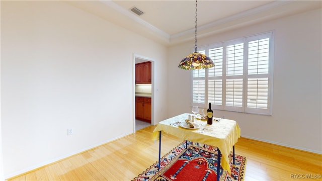 dining area featuring light wood-type flooring, visible vents, baseboards, and ornamental molding