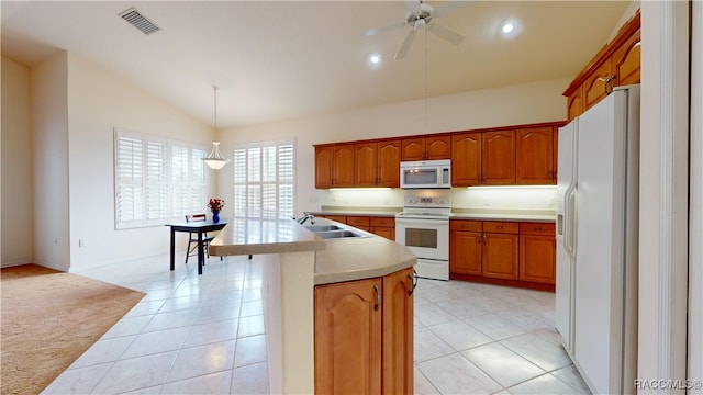 kitchen featuring white appliances, visible vents, lofted ceiling, a sink, and light countertops