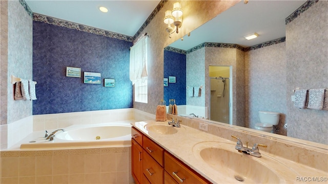 bathroom with wallpapered walls, a tub with jets, a stall shower, and a sink