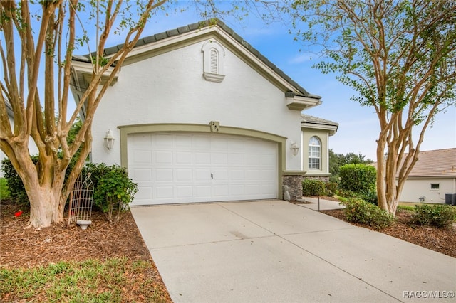 view of front of home featuring stucco siding, concrete driveway, an attached garage, and a tiled roof