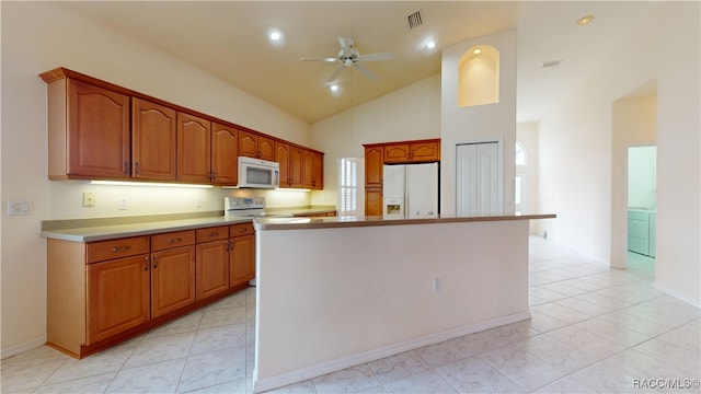 kitchen with visible vents, a center island, ceiling fan, brown cabinets, and white appliances