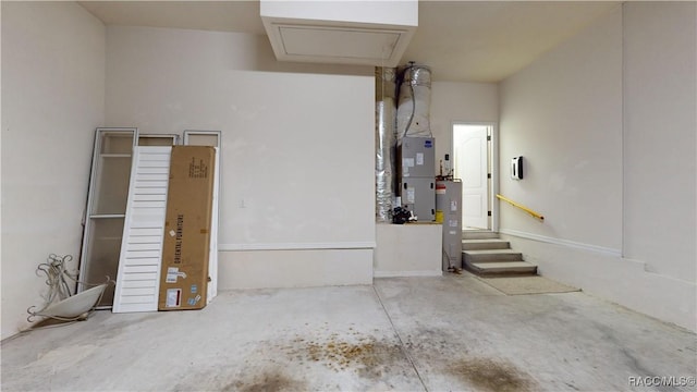 garage featuring heating unit and electric water heater