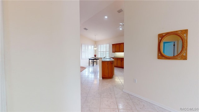 hallway with vaulted ceiling, baseboards, visible vents, and a sink