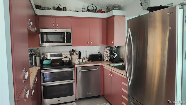 kitchen featuring decorative backsplash, a textured ceiling, and appliances with stainless steel finishes