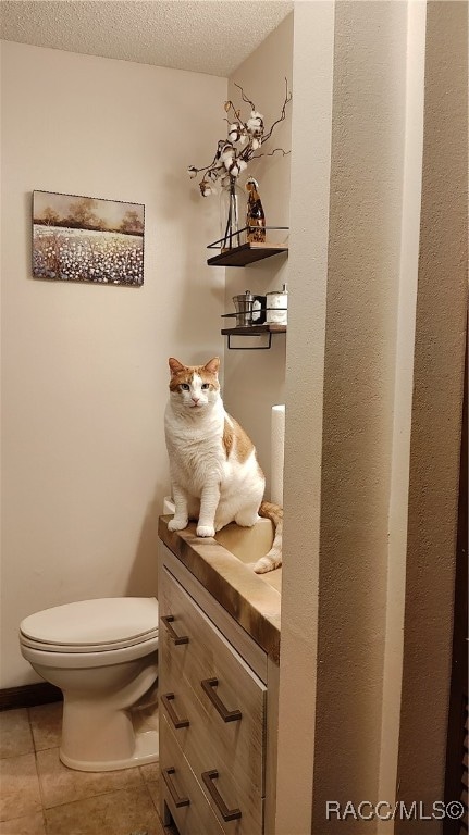 bathroom with vanity, tile patterned floors, a textured ceiling, and toilet