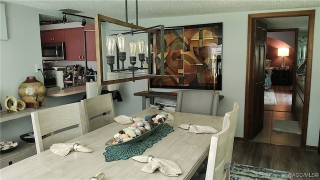 dining space featuring a textured ceiling and dark wood-type flooring