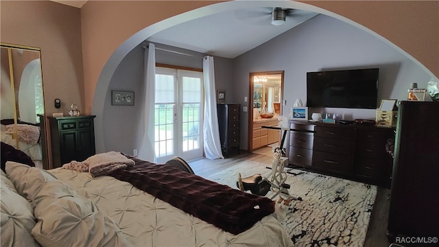 bedroom with ceiling fan, french doors, ensuite bathroom, light hardwood / wood-style floors, and lofted ceiling