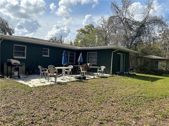 rear view of property with a patio and a lawn