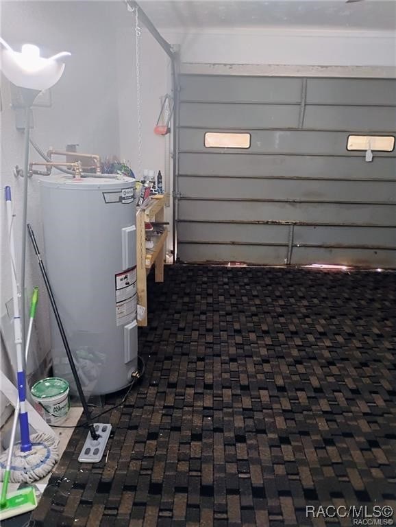 utility room with water heater and a garage