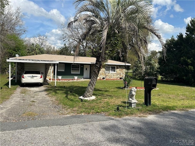 view of front of house with driveway, stone siding, an attached carport, and a front yard