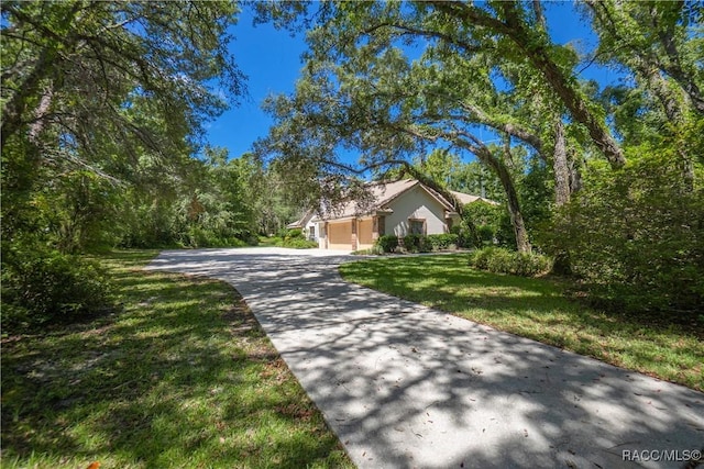 5550 W Yearling Dr, Beverly Hills, FL 34465 - view of front of property featuring an attached garage, a front yard, driveway, and stucco siding