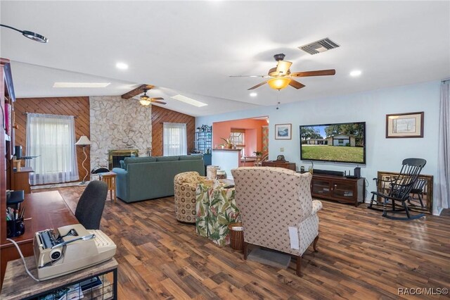 927 Cedar Ave, Inverness, FL 34452 - living room featuring ceiling fan, wood walls, wood finished floors, a fireplace, and a skylight