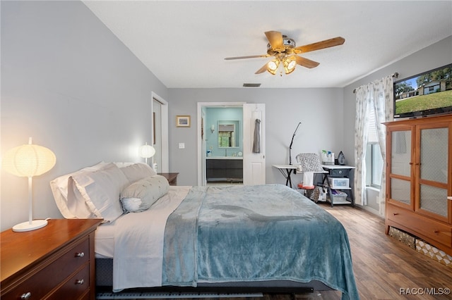 bedroom featuring dark hardwood / wood-style floors, ensuite bath, and ceiling fan