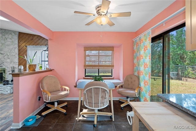 tiled dining area featuring a wealth of natural light, a fireplace, and ceiling fan