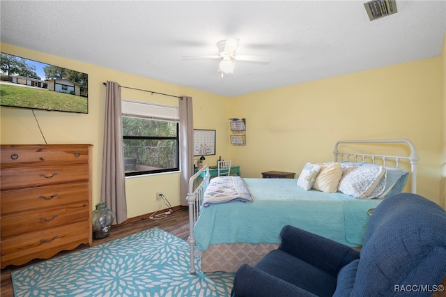 bedroom featuring ceiling fan, a textured ceiling, and hardwood / wood-style flooring