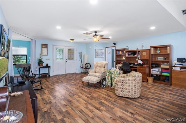 living room with dark hardwood / wood-style flooring and ceiling fan