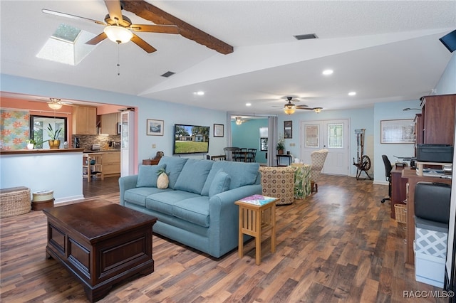 living room with dark hardwood / wood-style floors, ceiling fan, and vaulted ceiling with skylight