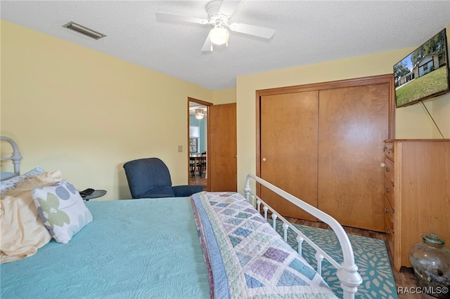 bedroom with a textured ceiling, a closet, and ceiling fan