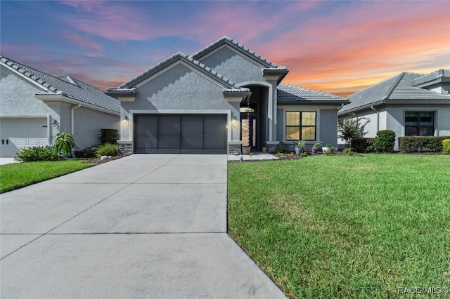 view of front facade featuring a lawn and a garage