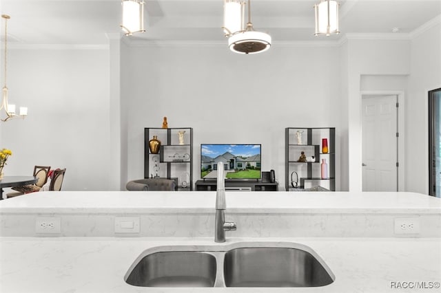 kitchen featuring crown molding, sink, light stone countertops, and decorative light fixtures