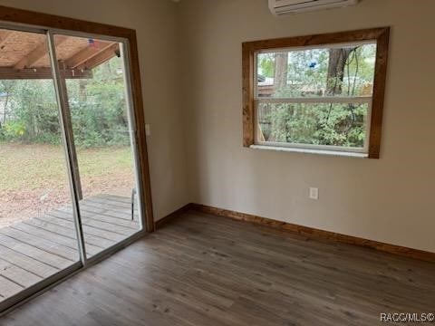 entryway with an AC wall unit and dark wood-type flooring