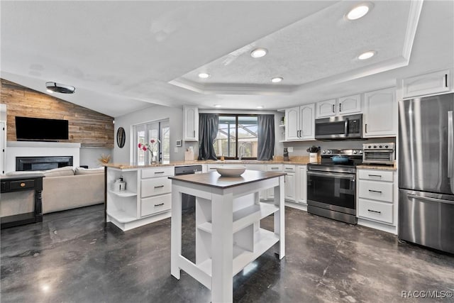 8638 Chadwick Dr, Tampa, FL 33635 - kitchen featuring appliances with stainless steel finishes, open shelves, a raised ceiling, a peninsula, and white cabinetry