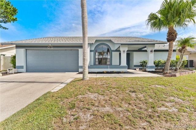 8638 Chadwick Dr, Tampa, FL 33635 - ranch-style home with stucco siding, central air condition unit, an attached garage, and concrete driveway