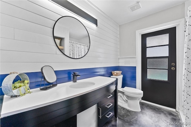 8638 Chadwick Dr, Tampa, FL 33635 - bathroom with wood walls, toilet, vanity, and concrete flooring