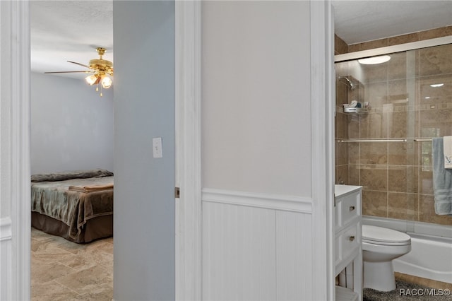 full bathroom featuring ceiling fan, vanity, enclosed tub / shower combo, and toilet