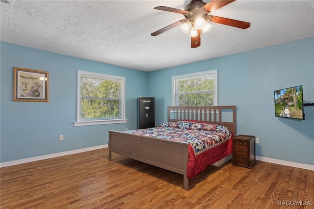 bedroom featuring ceiling fan, a textured ceiling, and hardwood / wood-style flooring