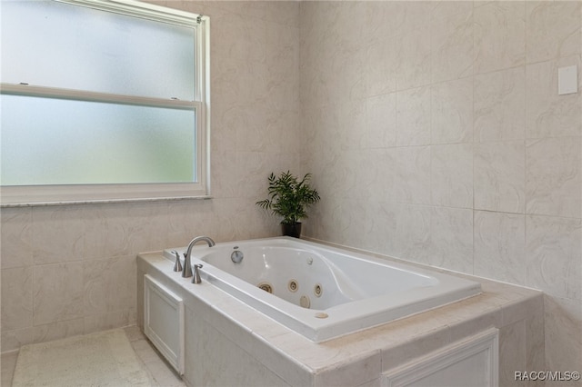 bathroom with a tub, tile patterned flooring, and tile walls