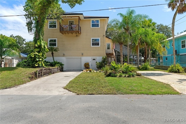 view of front facade featuring a front yard, a balcony, and a garage