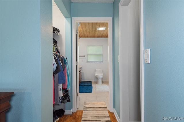 hall featuring light wood-type flooring and wood ceiling