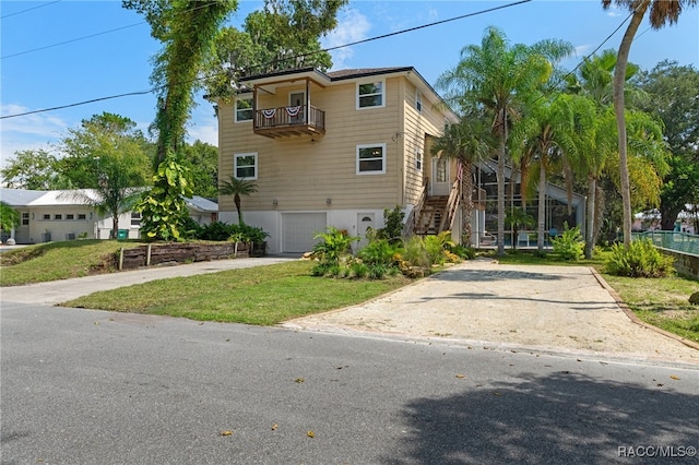 view of front of property with a garage, a balcony, and a front lawn