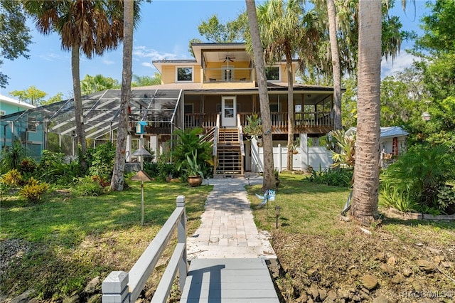 exterior space featuring a yard, ceiling fan, and a lanai