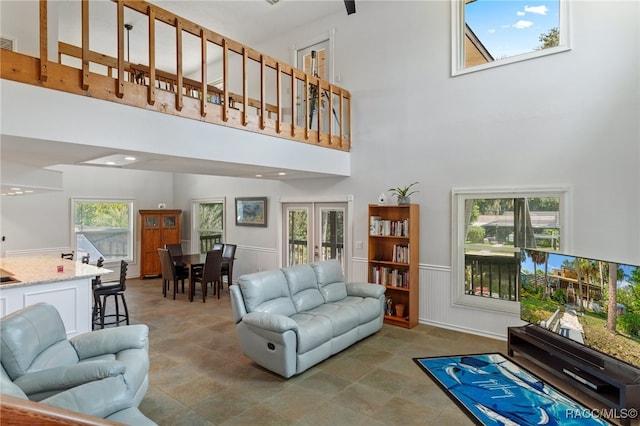 living room with plenty of natural light, a high ceiling, and french doors