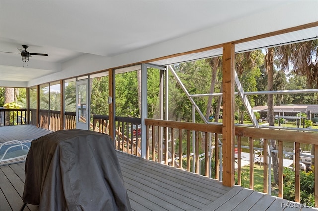 unfurnished sunroom with ceiling fan