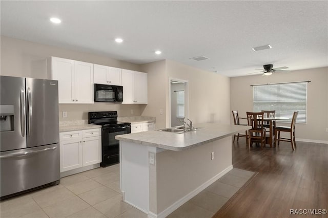 3417 N Michener Pt Unit 2C, Beverly Hills, FL 34465 - kitchen with black appliances, white cabinetry, a ceiling fan, light countertops, and an island with sink