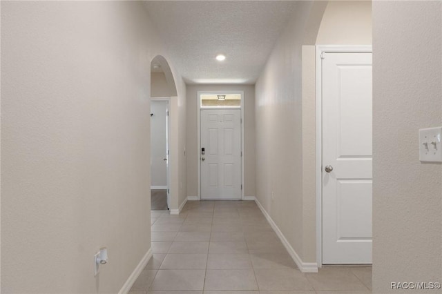 3417 N Michener Pt Unit 2C, Beverly Hills, FL 34465 - corridor with arched walkways, light tile patterned floors, and a textured ceiling