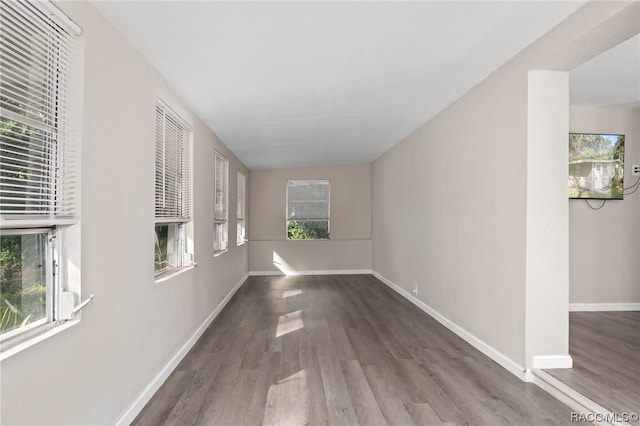 hallway with wood-type flooring and vaulted ceiling