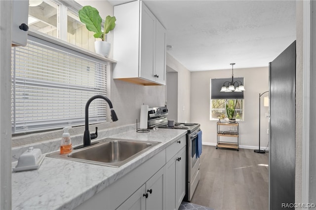 kitchen featuring sink, dark hardwood / wood-style floors, a chandelier, white cabinets, and appliances with stainless steel finishes