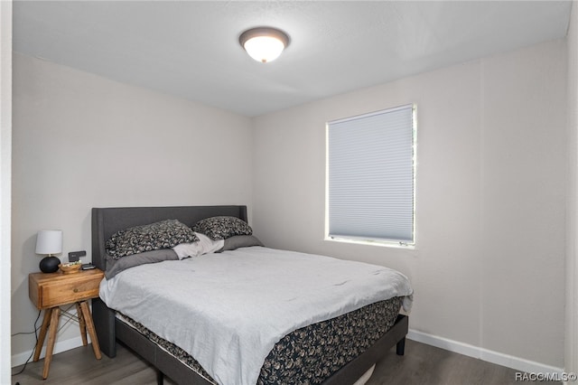 bedroom with dark hardwood / wood-style flooring