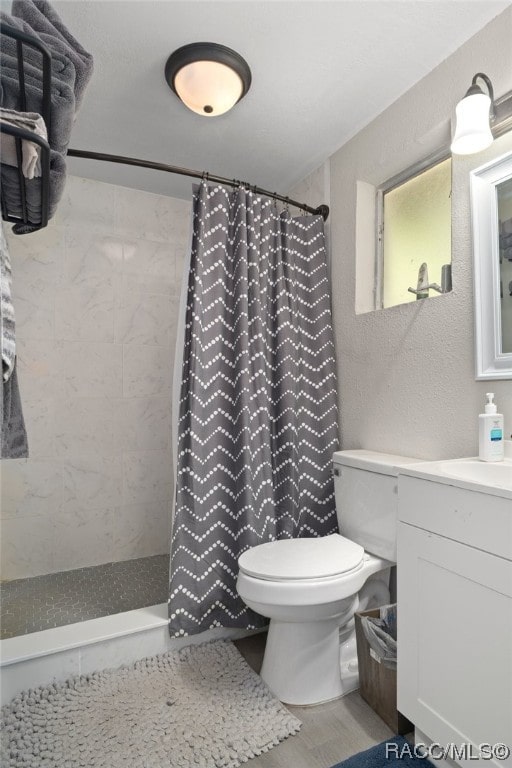 bathroom with a shower with shower curtain, vanity, and toilet