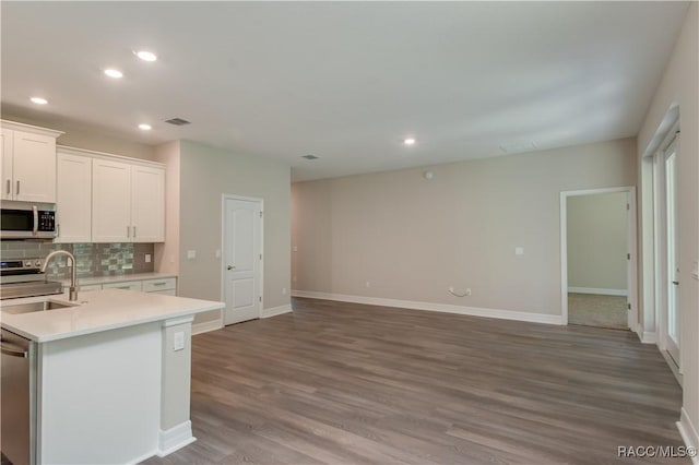 kitchen with recessed lighting, light countertops, tasteful backsplash, a sink, and stainless steel appliances