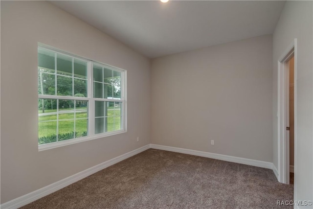 carpeted spare room featuring baseboards