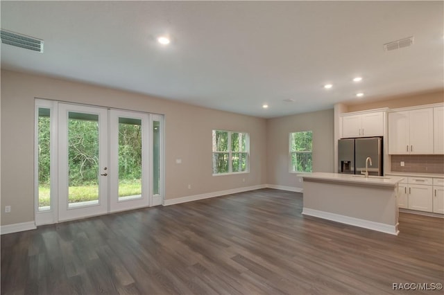 kitchen with open floor plan, visible vents, baseboards, and stainless steel fridge with ice dispenser