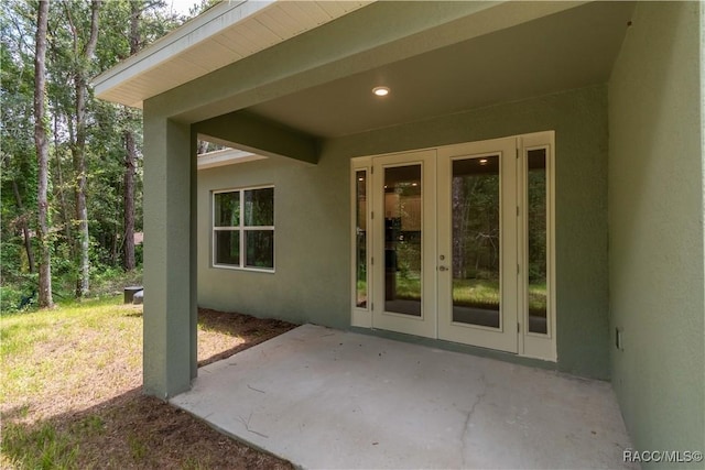 view of exterior entry featuring a patio, french doors, and stucco siding